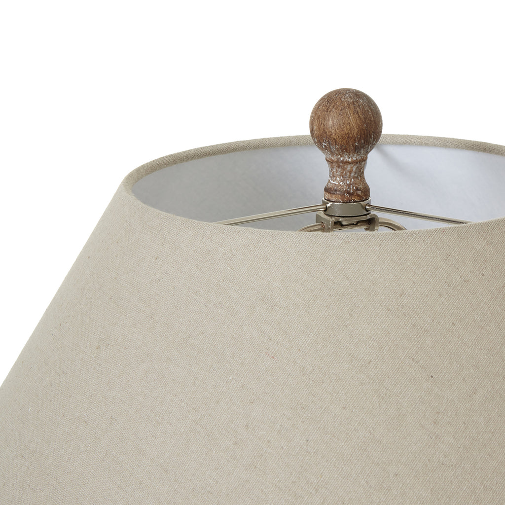 Close-up of the rounded brown finial above the pale woven-looking shade, with its open top visible.