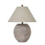 Rounded brown table lamp with horizontal ribs, a broad pale tan shade and round top finial on a white background.