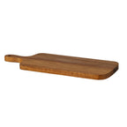 Serving board viewed at a low angle with the handle to the left, showing its flat brown grained surface and rounded front edge.