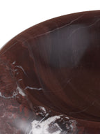 Close-up of the bowl's rounded rim and interior, showing dark red stone with fine pale veins and white markings.