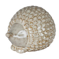 Three-quarter view of a cream-white hedgehog decoration with a domed scale-patterned back, pointed snout and short front feet.