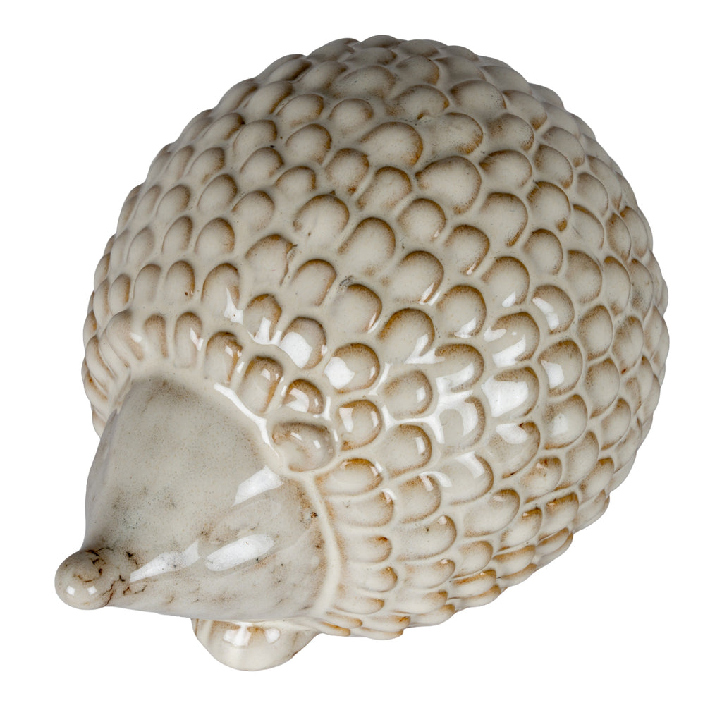View from above of the hedgehog's overlapping rounded scales, glossy highlights and mottled cream snout pointing to the left.