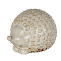 Cream-white hedgehog decoration viewed from the front side, showing a raised rounded nose, short feet and a glossy back of overlapping scales.