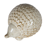 Hedgehog decoration viewed from above at an angle, showing the high domed back covered in rounded cream scales and the smooth face pointing towards the lower left.