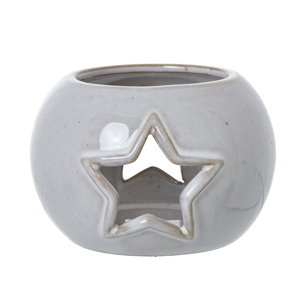 Front view of the rounded off-white candle holder with a tan-edged star opening and circular top rim.