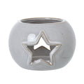 Front view of the rounded off-white candle holder with a tan-edged star opening and circular top rim.