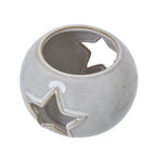 Angled view from above showing the candle holder's circular opening, glossy curved surface and star cut-outs in the sides.