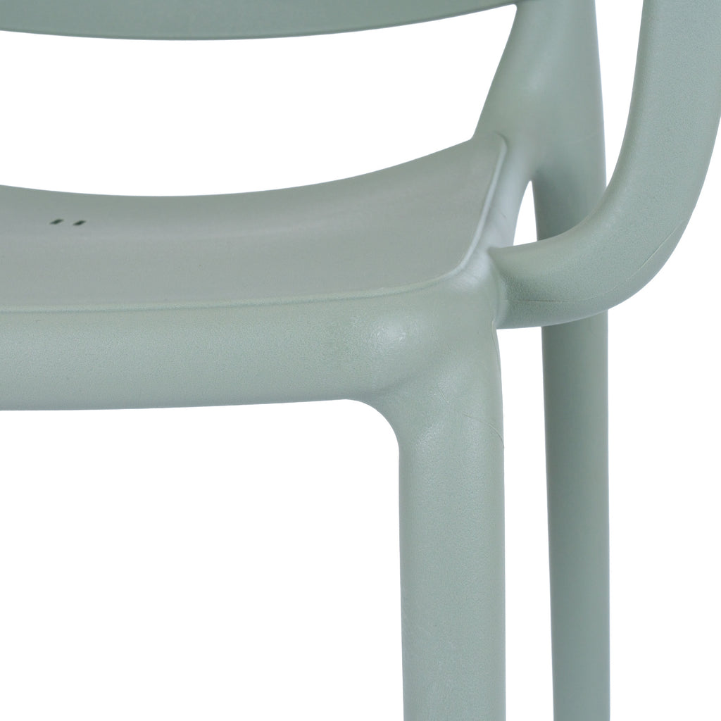 Close-up of the green-grey chair's seat edge, curved arm and front leg, showing the fine pebbled surface texture.