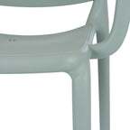 Close-up of the green-grey chair's seat edge, curved arm and front leg, showing the fine pebbled surface texture.
