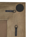 Rear corner of the mirror showing two black ring fittings, their screws and a round black pad against the brown frame.