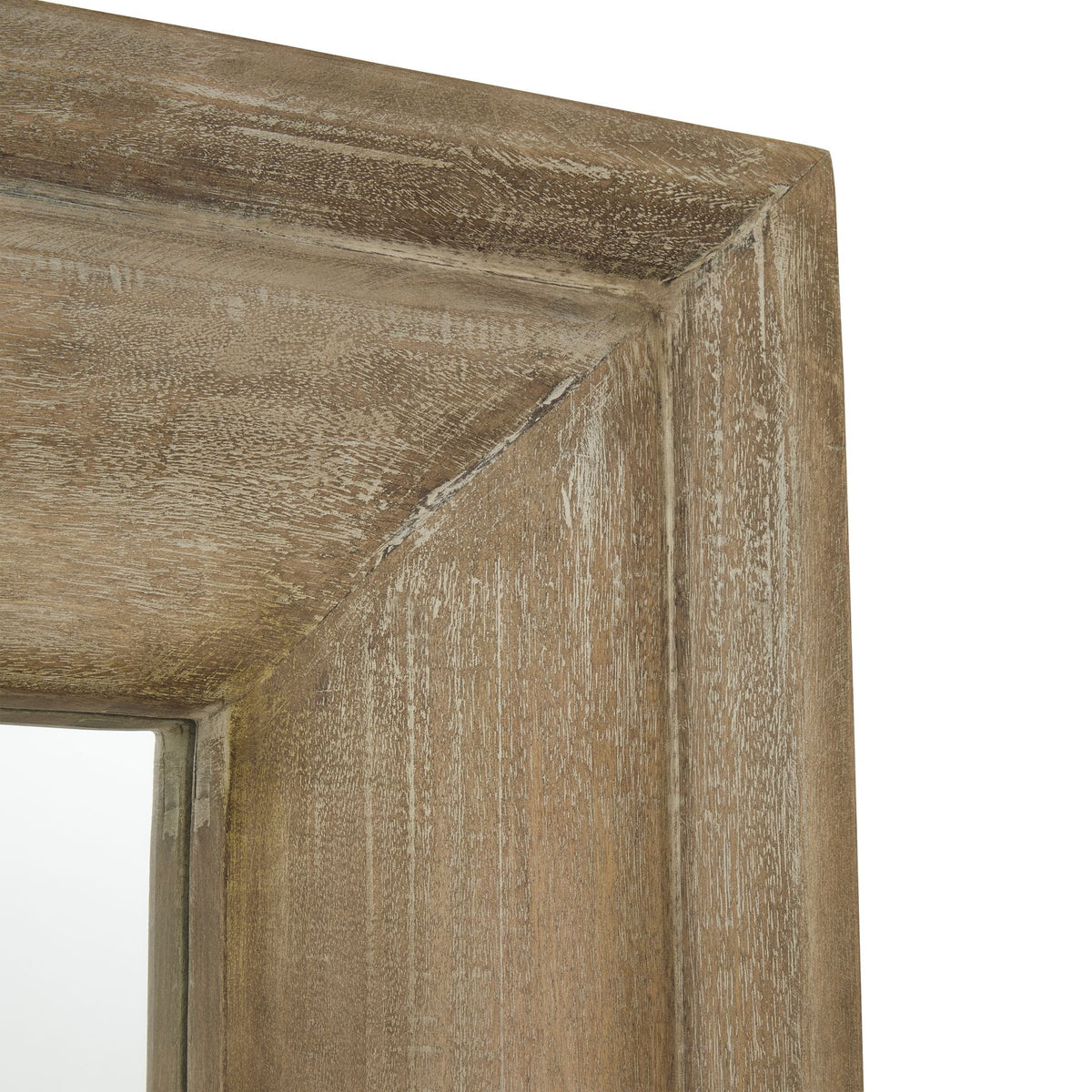 Close-up of the mirror's upper frame corner, showing the sloping moulding and pale grain-like streaks across the brown finish.