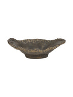 Low side view of the dark bronze bowl, showing its uneven raised edges and short circular base.