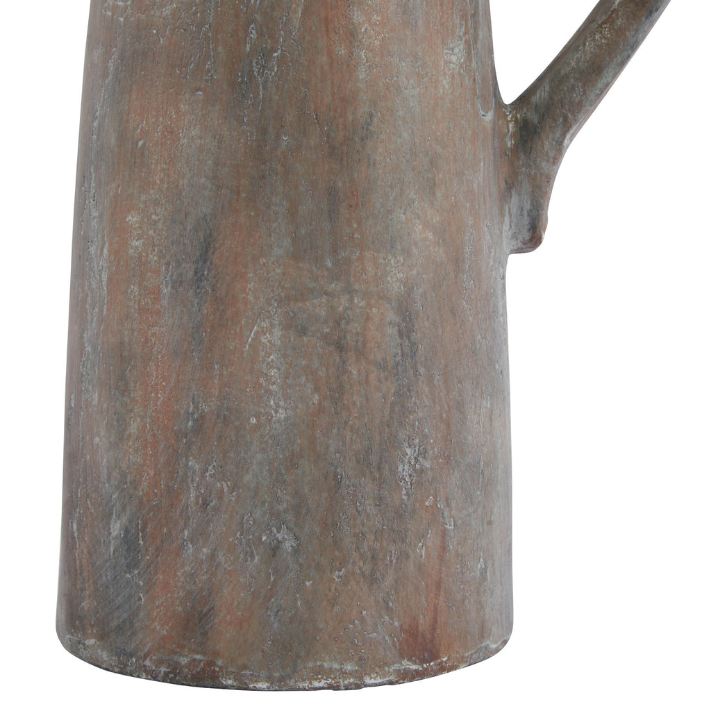 Detail of the jug's lower body and base, with pale grey flecks and dark vertical streaks over a rust-brown finish.