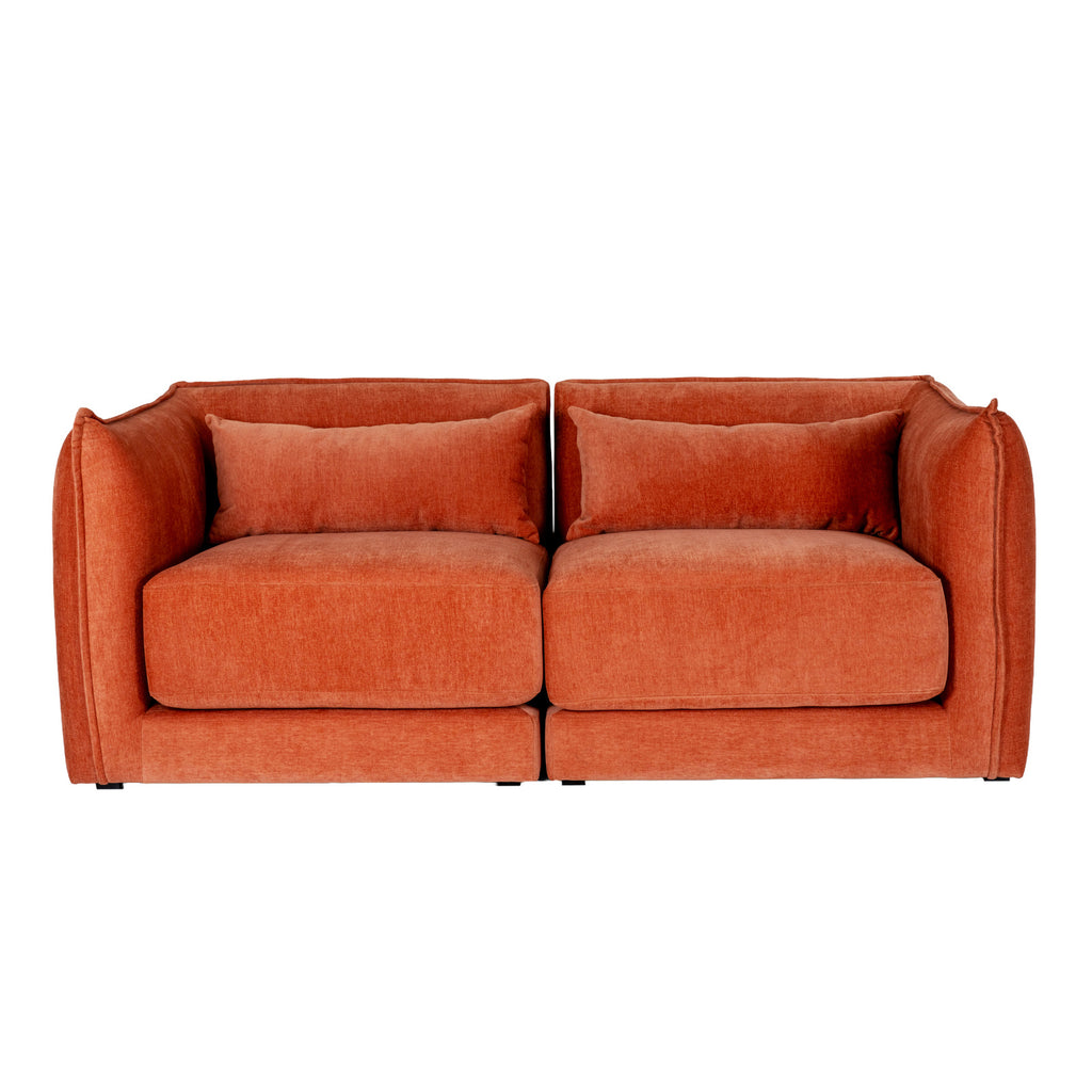 Front view of the rust-orange sofa with a central division, two thick seat cushions and short dark feet.