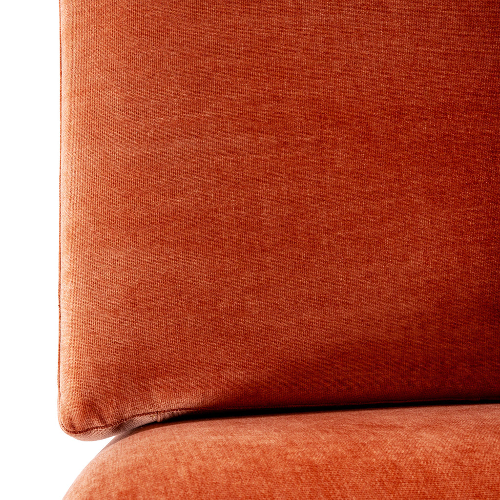 Close-up of a rust-orange back cushion showing the fine surface texture and its lower edge above the seat.