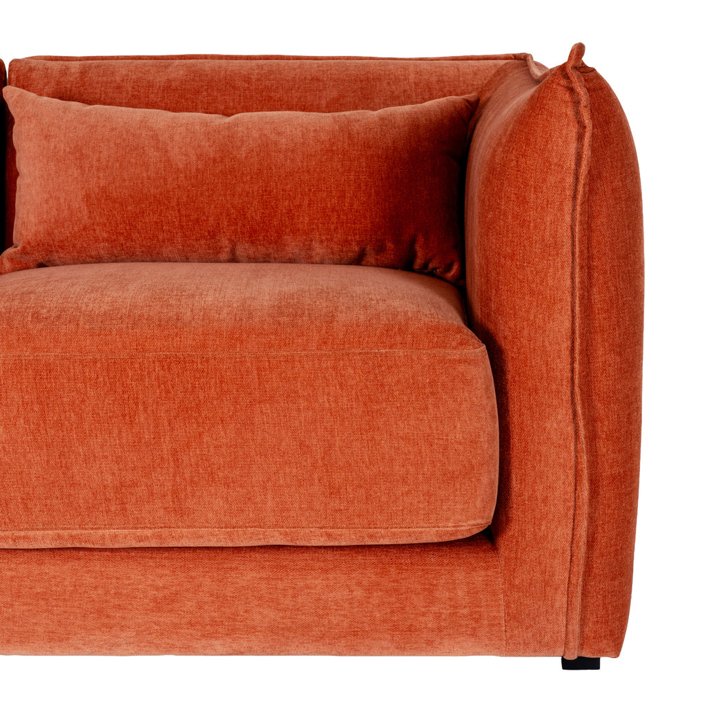 Detail of the sofa's right arm with its raised seam beside a rectangular back cushion and thick seat cushion.