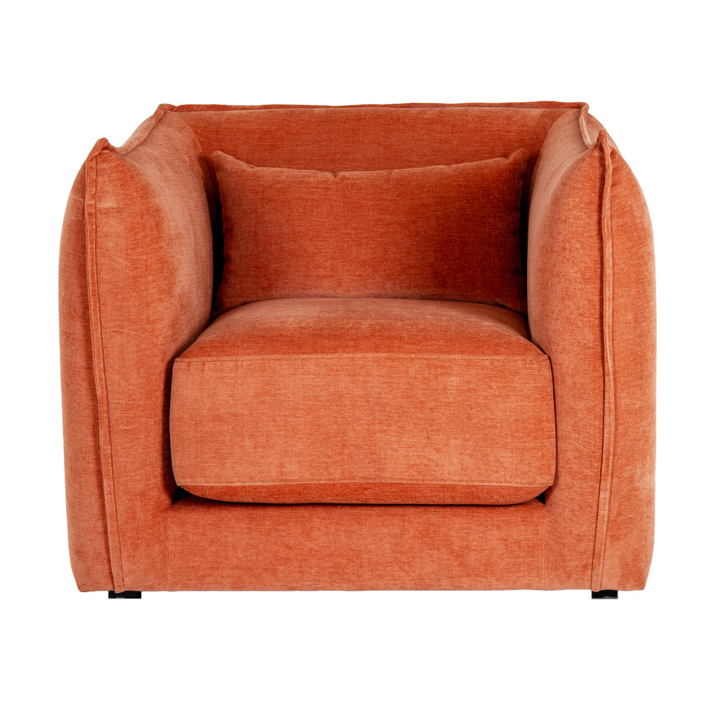 Front view of the rust-orange armchair, showing curved sides around a thick seat cushion, a rectangular cushion and short dark feet.