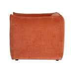 Rear view of the rust-orange armchair, showing its broad rounded back, raised edging and short dark feet.
