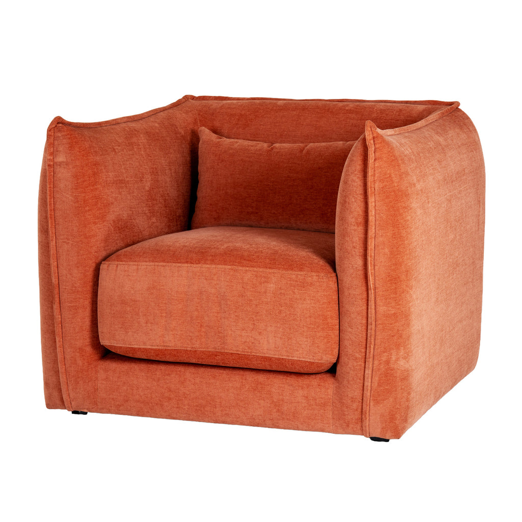 Three-quarter front view of a rust-orange armchair with rounded enclosing sides, a thick seat cushion and a matching rectangular cushion.