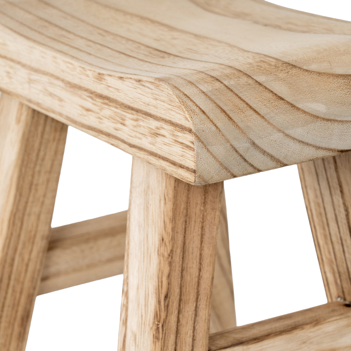Close-up of the stool's curved seat corner with pale tan colouring, fine grain texture and darker lines above the splayed legs.