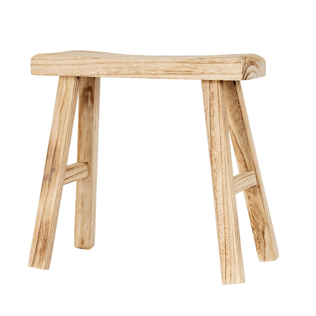 Broad side view of the pale tan stool showing the dipped seat profile, outward-sloping legs and crossbars at either end.