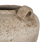 Close-up of a chunky loop handle beside the vase rim, showing brown mottling and fine speckles on the sandy surface.