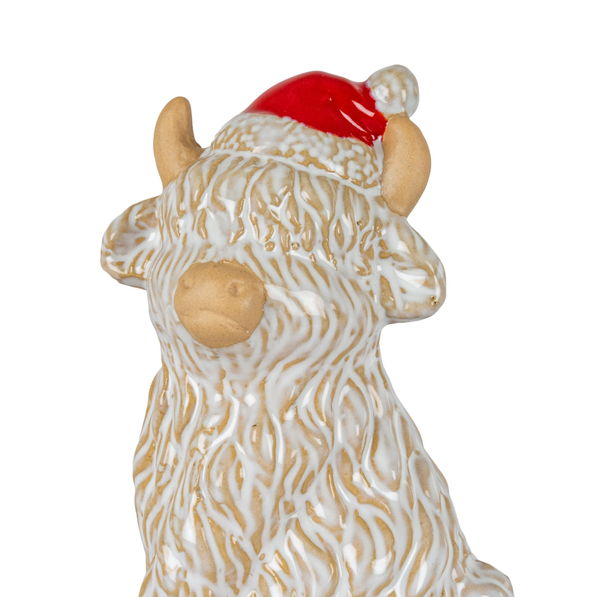 Close-up of the cow decoration's head and upper body, showing raised cream coat texture over tan, side ears, horns and a glossy red hat with textured pale trim.