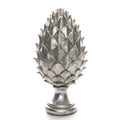 Silver-coloured pinecone finial with overlapping pointed scales, a narrow pedestal neck and rounded stepped base against white.