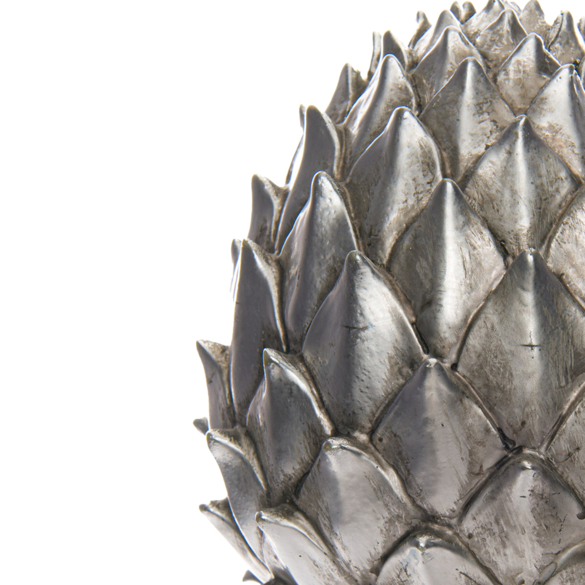 Close-up of the pinecone finial's overlapping scales, showing bright silver-coloured ridges, darker recesses and mottled surface markings.