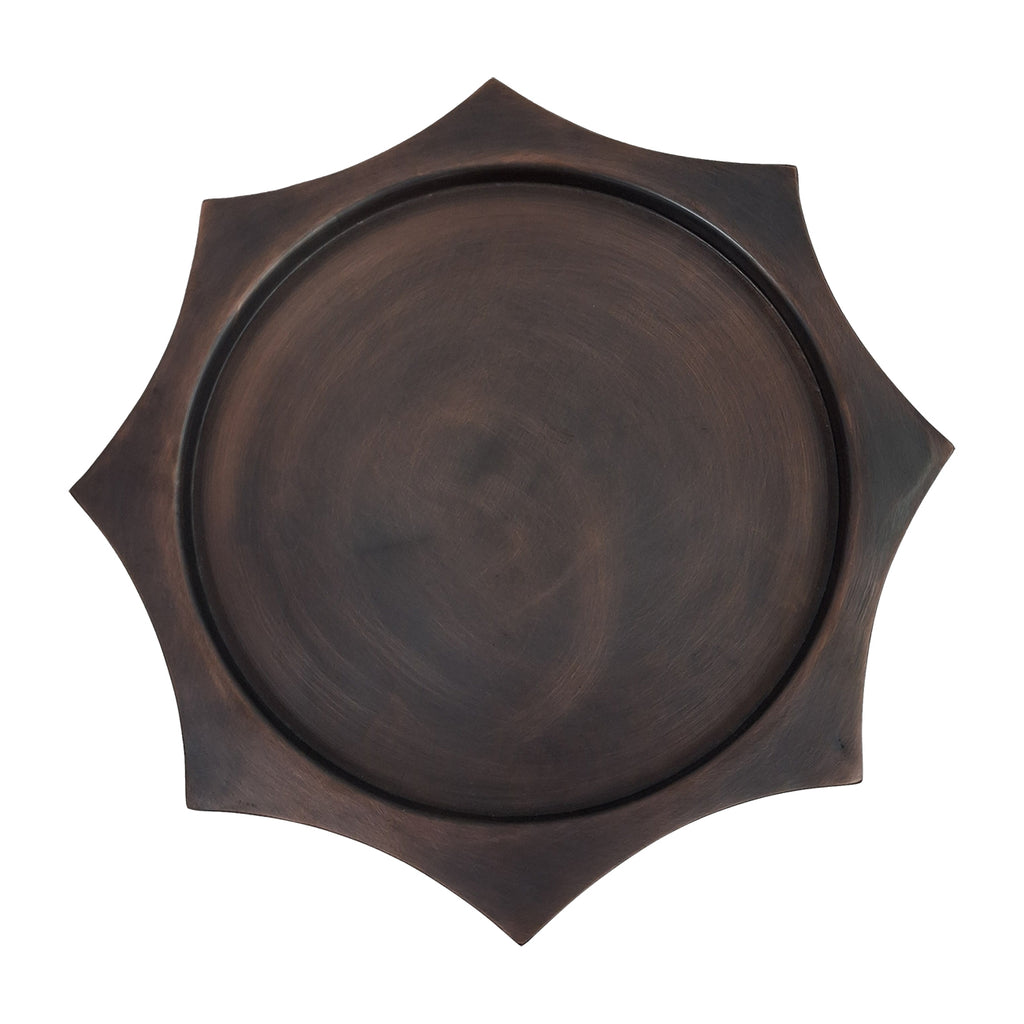 Overhead view of the circular bronze display surface surrounded by the scalloped hexagonal edge.