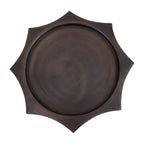 Overhead view of the circular bronze display surface surrounded by the scalloped hexagonal edge.