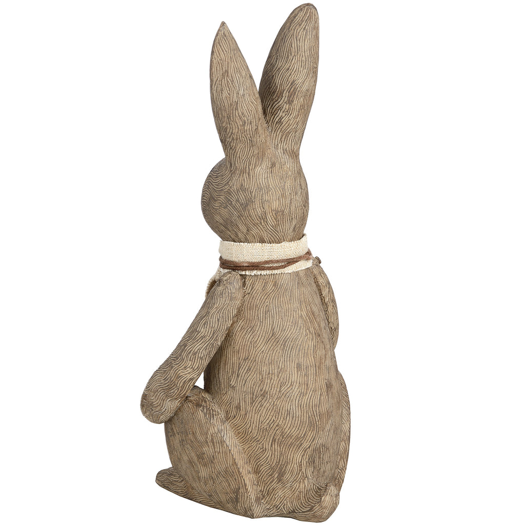 Rear view of the rabbit ornament showing fur-like lines across its back, a small tail and the cream and brown scarf around its neck.
