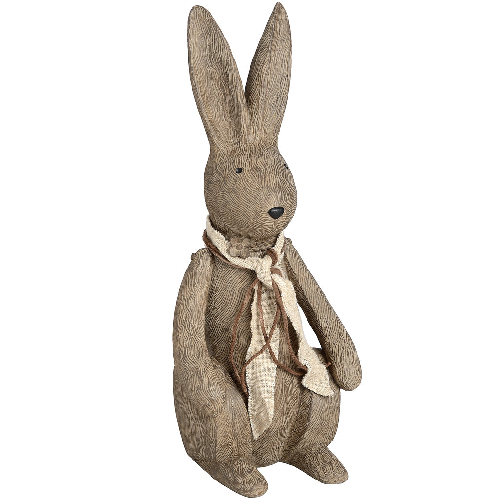 Large upright rabbit ornament with long ears, black eyes and nose, and a cream scarf tied with brown strands, viewed from the front at an angle.
