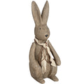 Large upright rabbit ornament with long ears, black eyes and nose, and a cream scarf tied with brown strands, viewed from the front at an angle.