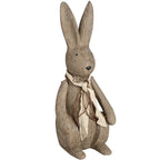 Large upright rabbit ornament with long ears, black eyes and nose, and a cream scarf tied with brown strands, viewed from the front at an angle.