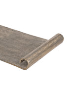 Detail of the tray's curled end, showing the open circular profile and brighter metal edge.