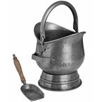 Coal bucket viewed from the shovel-holder side, with the shovel resting separately to the left and its scoop facing upwards.