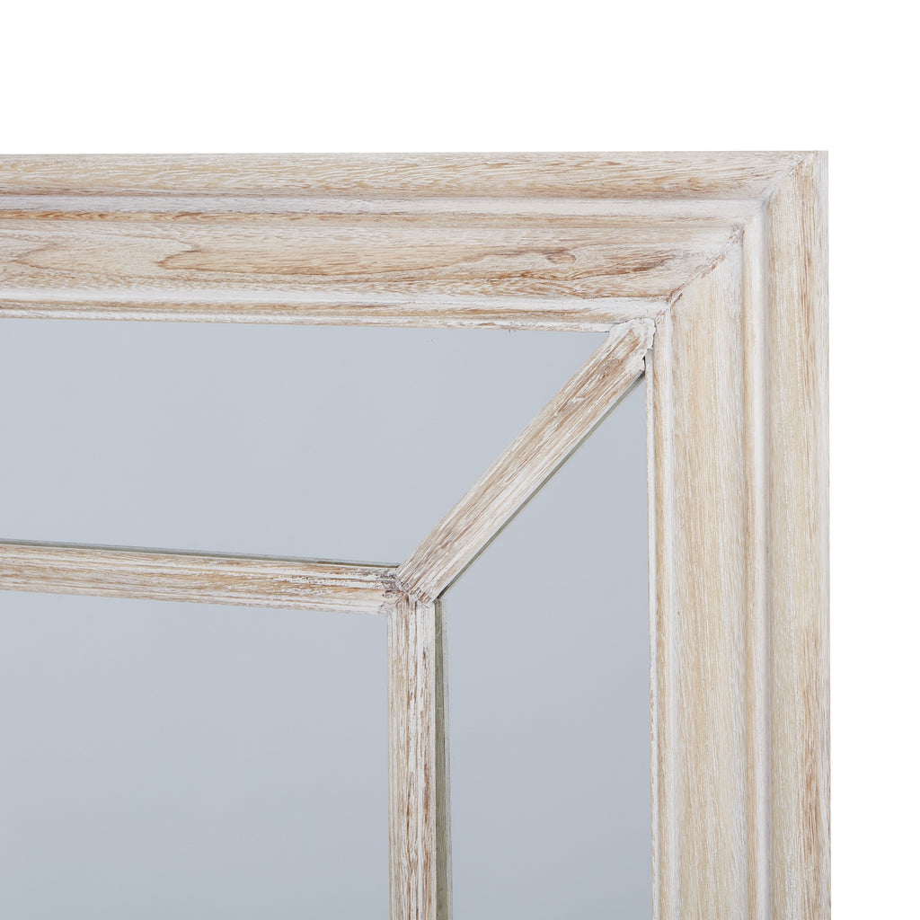 Close-up of the mirror's upper right corner, showing the diagonal border divider and white streaking across the beige wood-look frame.