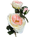 Close-up of blush pink and cream artificial rose-form flowers, with a large open bloom below a smaller bloom and closed bud among dark green serrated leaves.