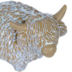 Close-up of the Highland cow ornament's face, showing its long textured fringe, sweeping horns and smooth rounded muzzle.