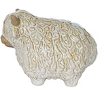 Side view of the Highland cow ornament facing left, showing the raised strands across its glossy white coat and rounded body.