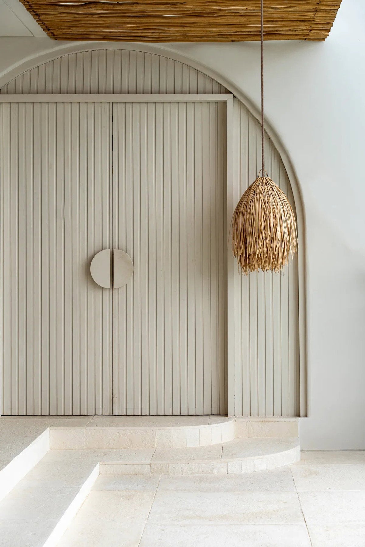 Shaggy Rattan Pendant Light – Natural, Medium – styled beside an arched doorway