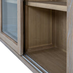 Close-up of the lower cabinet interior, showing the grain of the back and side panels beside the glazed frame and bottom track.