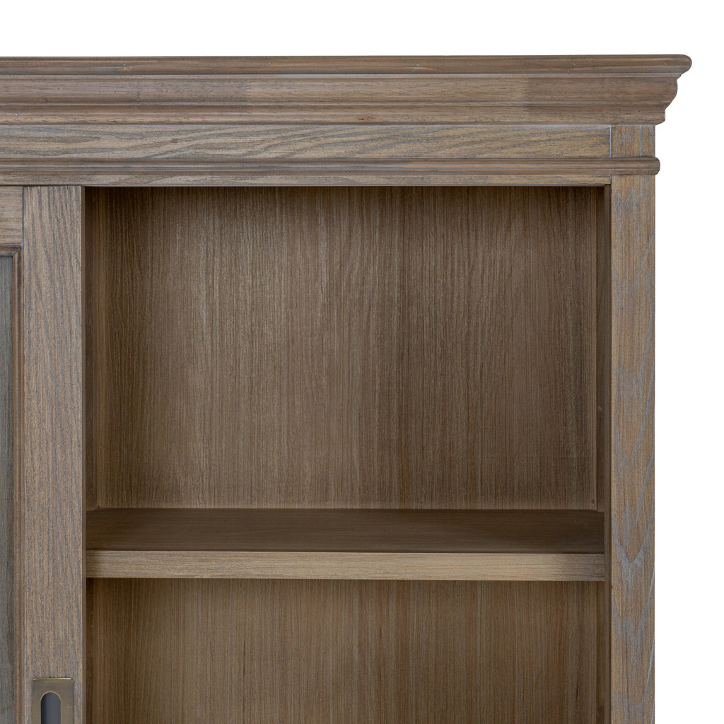 Detail of the shaped crown and upper shelf, with grey-brown grain visible across the frame and interior panels.