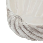 Detail of the planter's curved rim and radiating exterior ribs beneath the cream-white inner bowl.