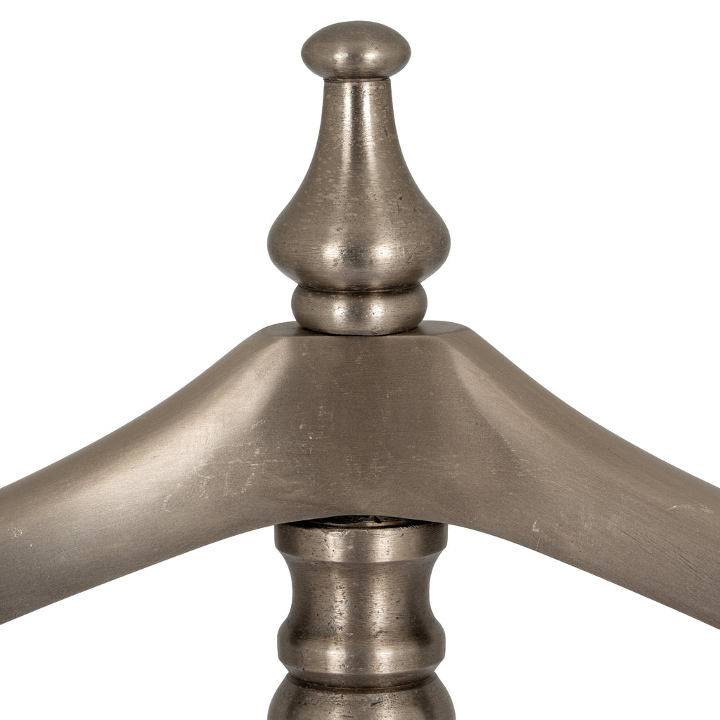 Detail of the rounded finial and sweeping shoulder hanger, showing the valet stand's softly reflective antiqued silver-tone surface.
