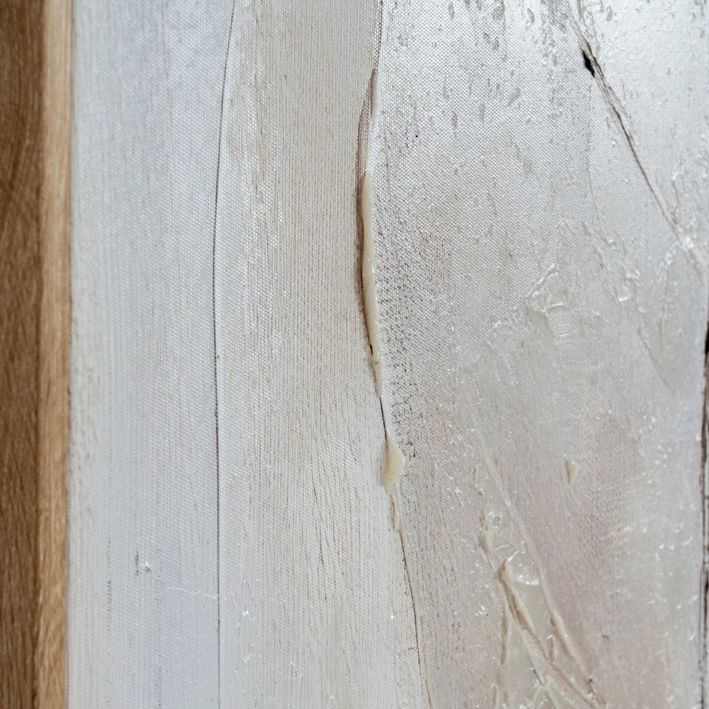 Close-up of the leaf's curved edge, showing cream raised ridges, fine dark lines and canvas weave beside the left frame edge.