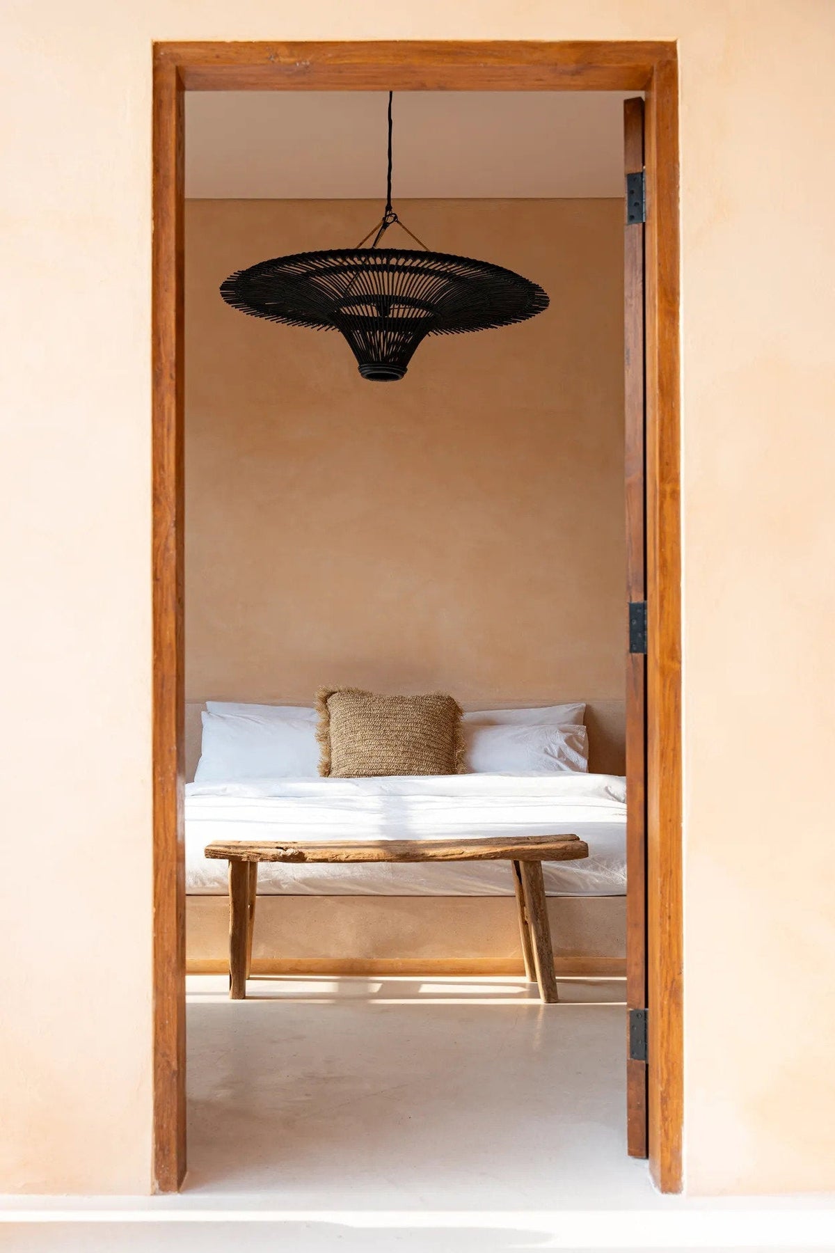 Sky Rattan Pendant Light – Black, Extra Large – styled above a daybed through a doorway