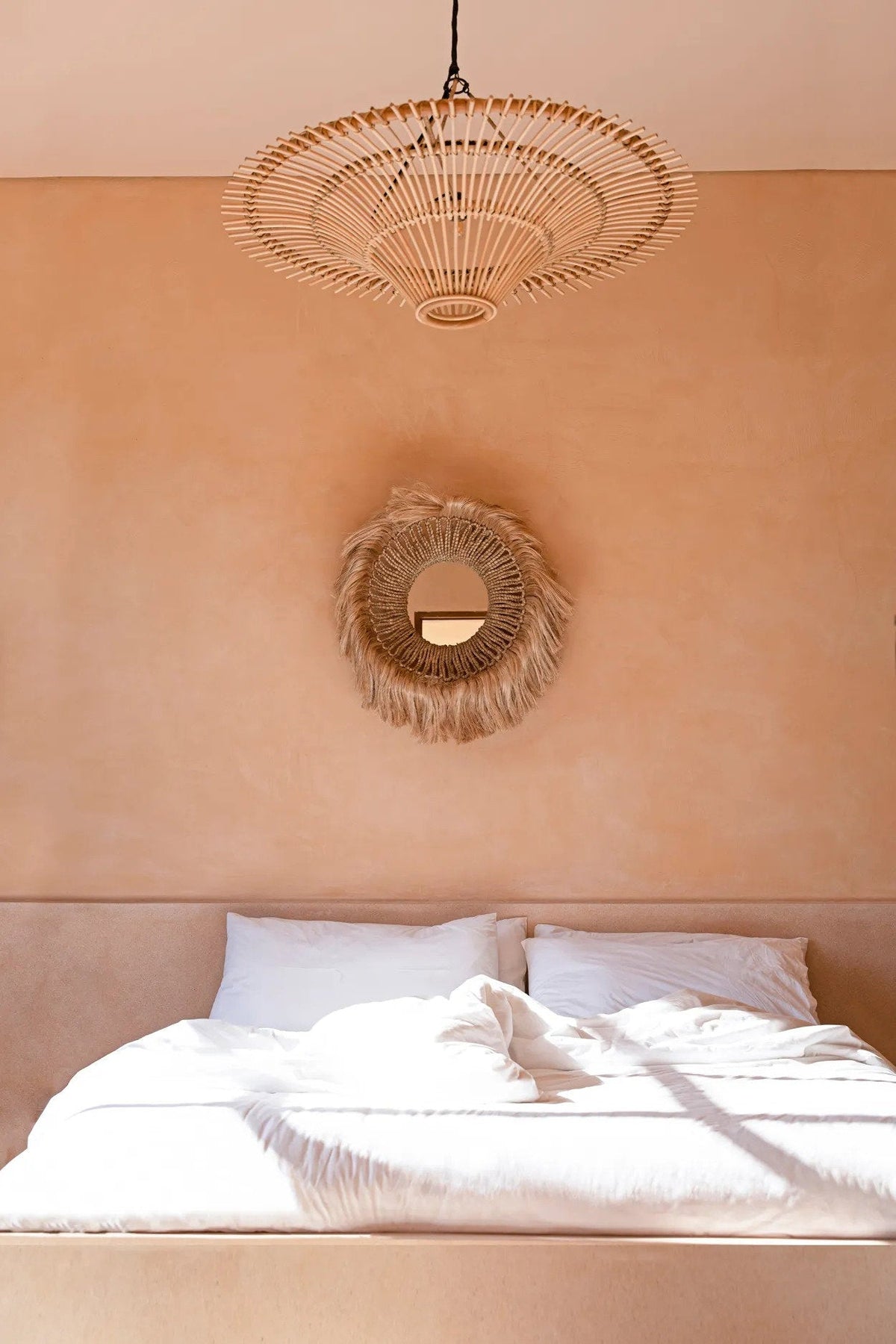 Sky Rattan Pendant Light – Natural, Large – styled above a bed with a wall mirror