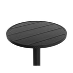 Angled close-up of the black circular tabletop showing broad parallel slats and the enclosing rim.